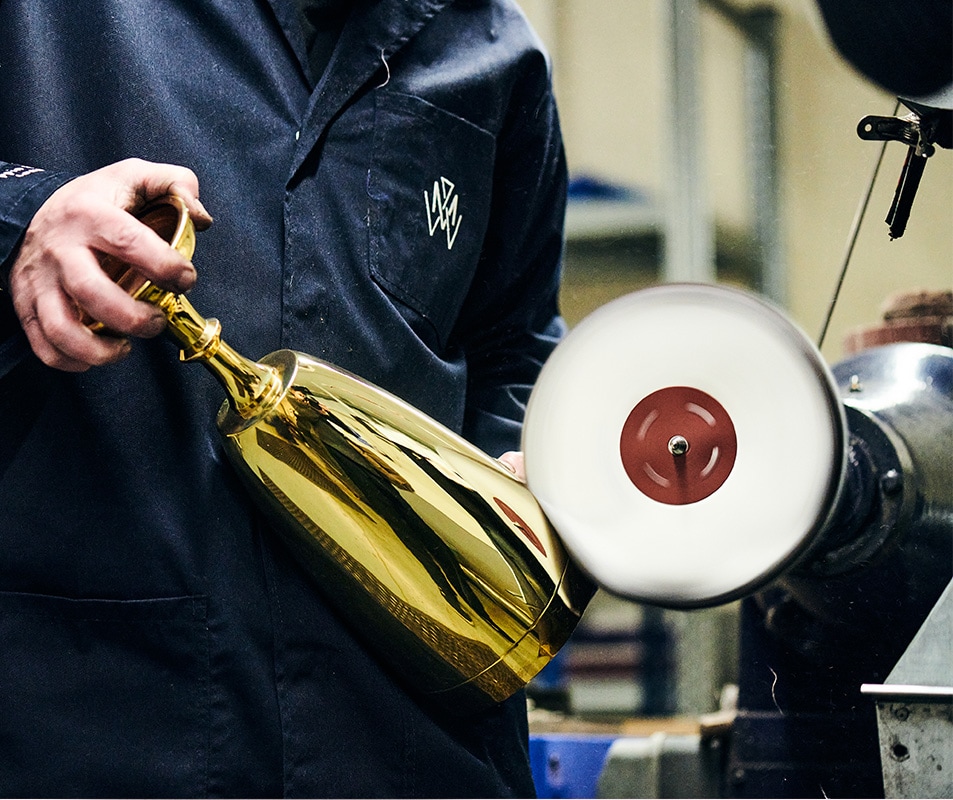 A craftsman shaping silver with a tool