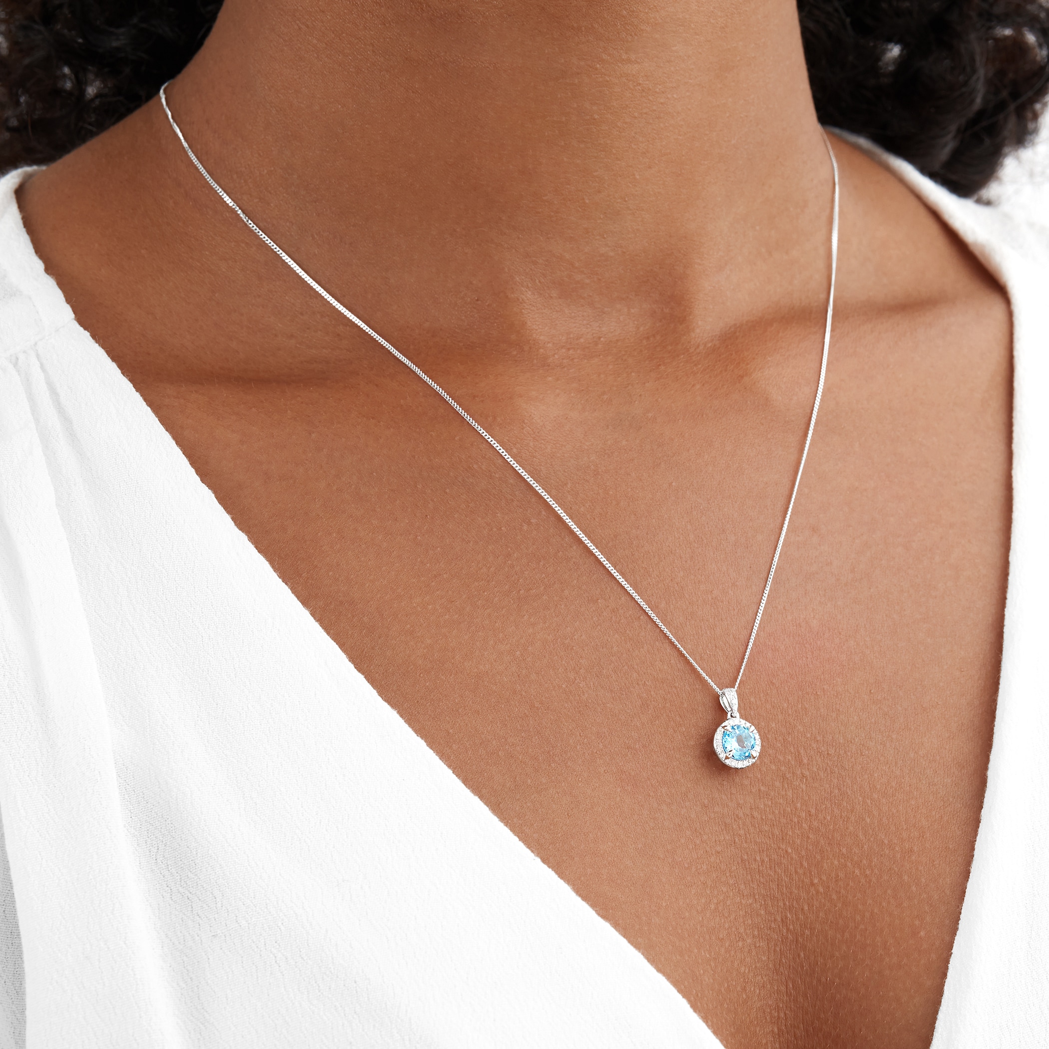 Goldsmiths 9ct White Gold Blue Topaz and Diamond Halo Pendant Goldsmiths 9ct White Gold Blue Topaz and Diamond Halo Pendant